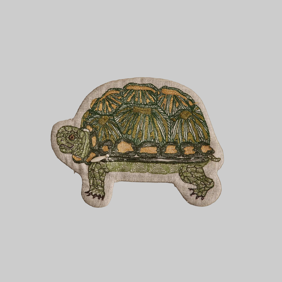 Coral and Tusk's Turtle pouch featuring a green and golden turtle design embroidered on 100% linen. Has two zipper compartments.