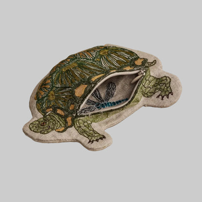 Coral and Tusk's Turtle pouch featuring a green and golden turtle design embroidered on 100% linen. Has two zipper compartments.