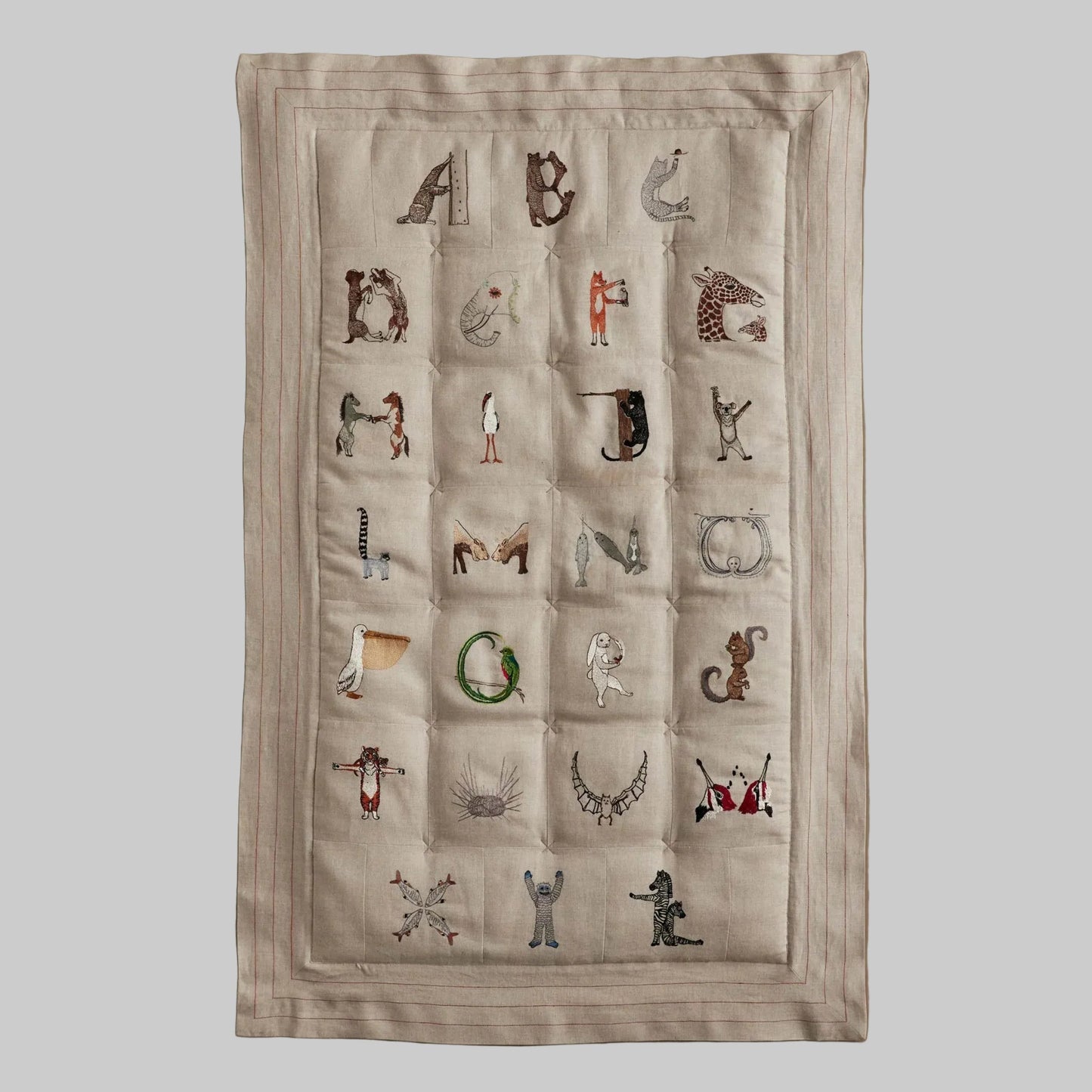 Coral and Tusk's embroidered linen quilt for children or a nursery. Feature alphabet designs with animals playfully representing each letter. 