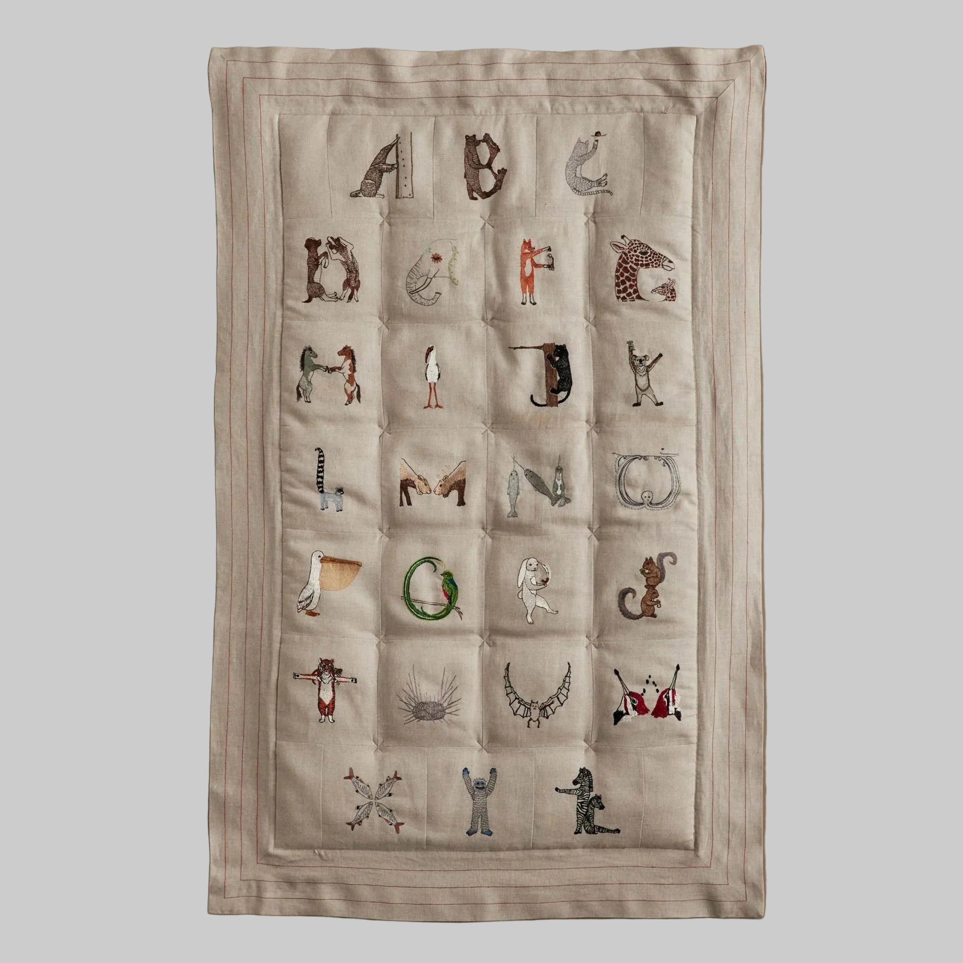 Coral and Tusk's embroidered linen quilt for children or a nursery. Feature alphabet designs with animals playfully representing each letter. 