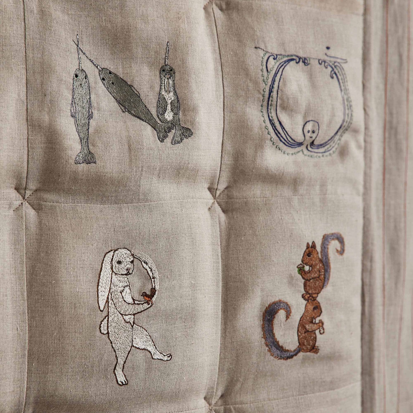 Coral and Tusk's embroidered linen quilt for children or a nursery. Feature alphabet designs with animals playfully representing each letter.