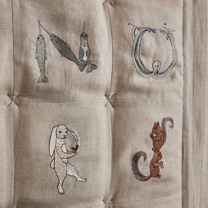 Coral and Tusk's embroidered linen quilt for children or a nursery. Feature alphabet designs with animals playfully representing each letter.