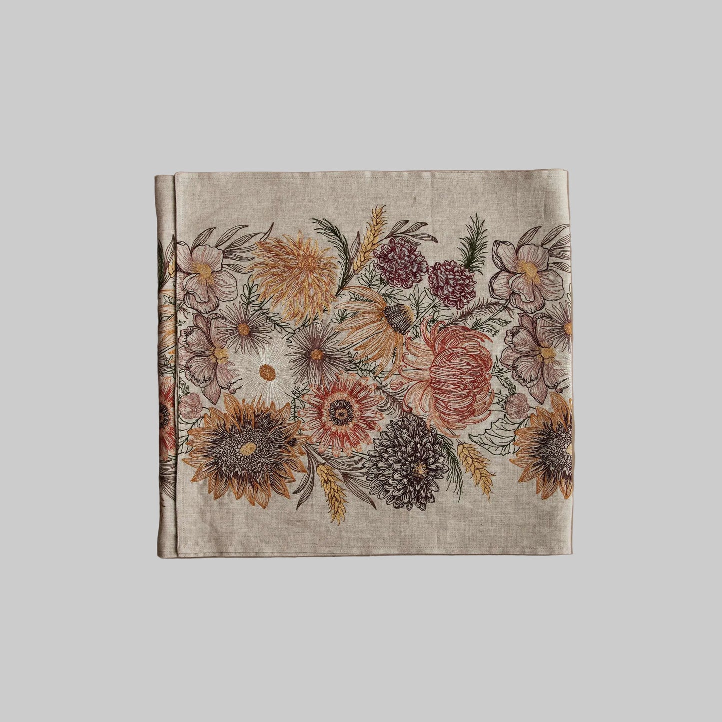 Coral and Tusk’s “Autumn Blossoms” embroidered linen table runner featuring earth tone florals and wheat stems