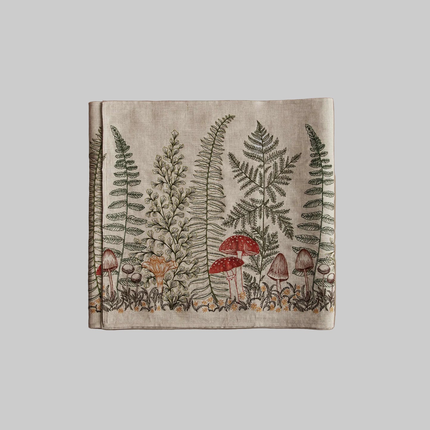 Coral and Tusk’s “Mushrooms and Ferns” embroidered linen table runner featuring a variety of mushrooms surrounded by fern fronds
