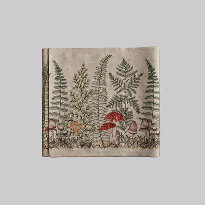 Coral and Tusk’s “Mushrooms and Ferns” embroidered linen table runner featuring a variety of mushrooms surrounded by fern fronds