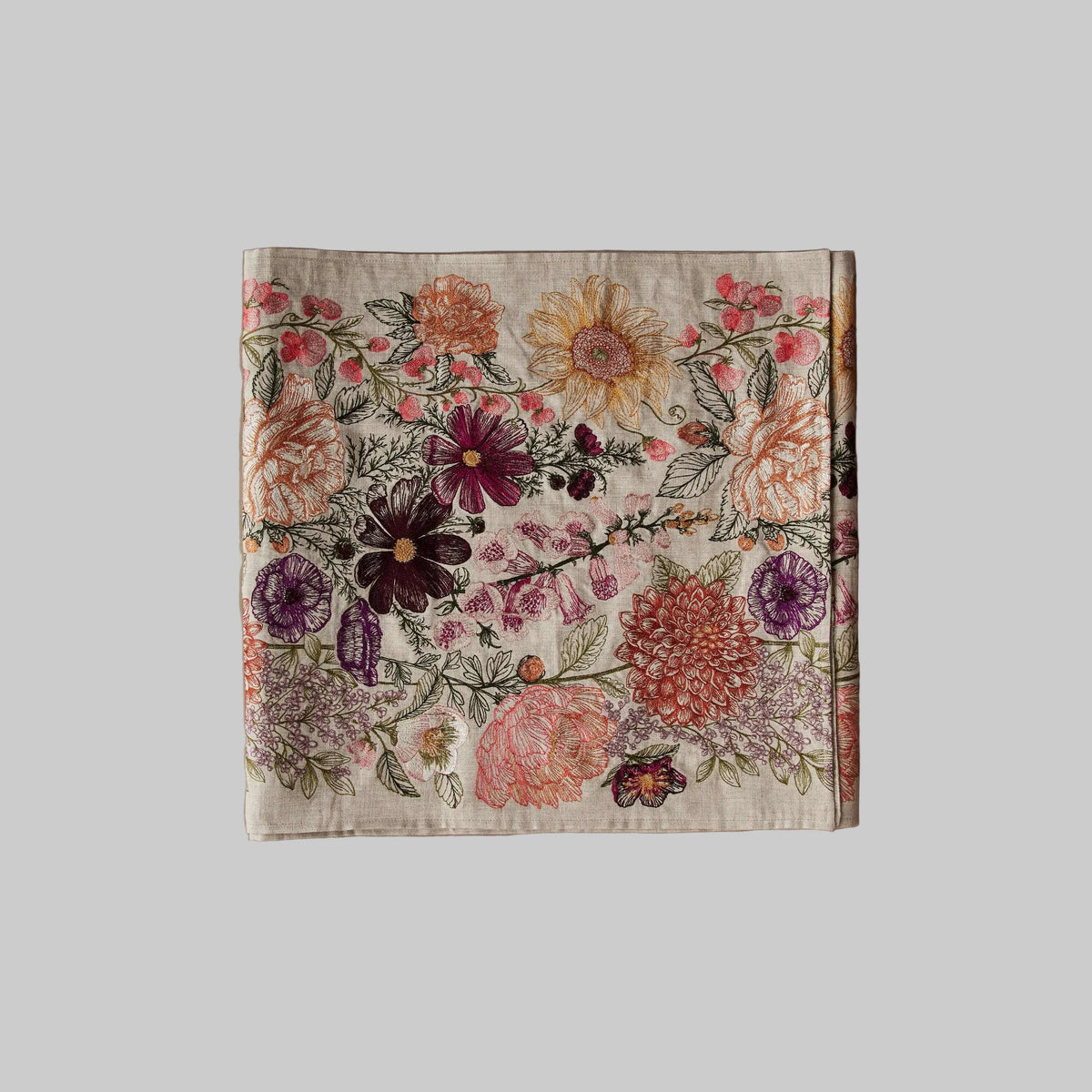 Coral and Tusk’s “Paradise Garden” embroidered linen table runner featuring vibrant florals in pinks, yellows, and maroons