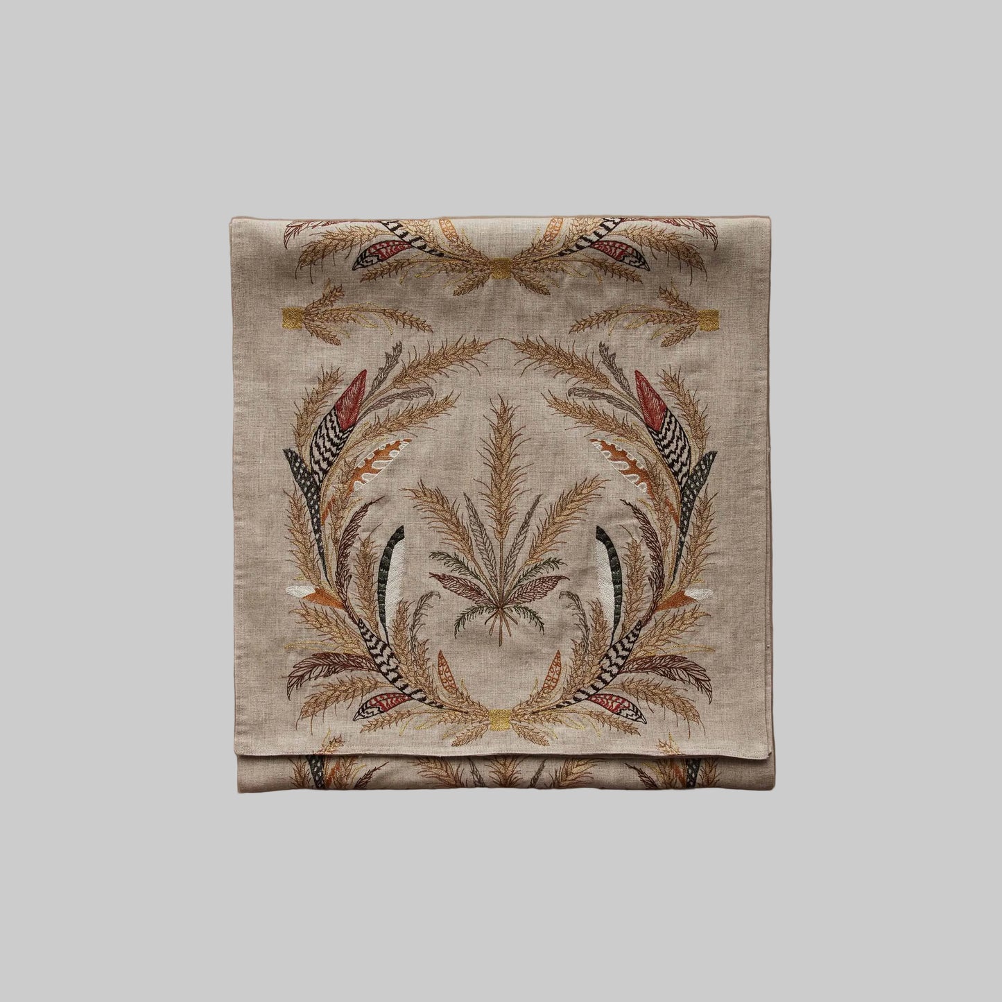 Coral and Tusk’s “Wheat Harvest” embroidered linen table runner featuring wreaths of gather wheat, grass, and feathers