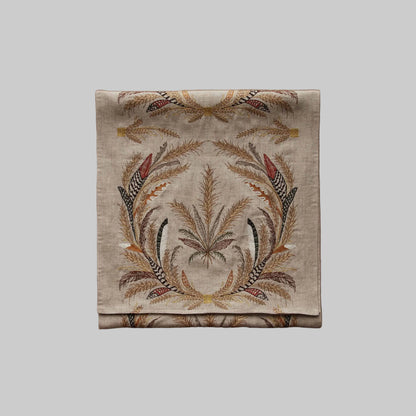 Coral and Tusk’s “Wheat Harvest” embroidered linen table runner featuring wreaths of gather wheat, grass, and feathers