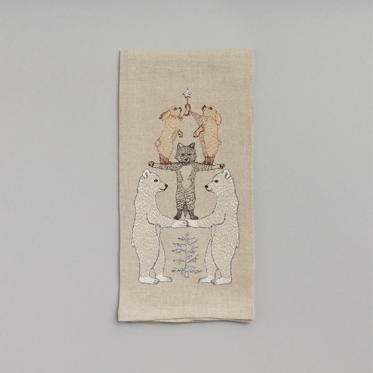 Coral and Tusk's "Arctic Tree" embroidered linen tea towel featuring a stack of wintery animals forming a Christmas tree