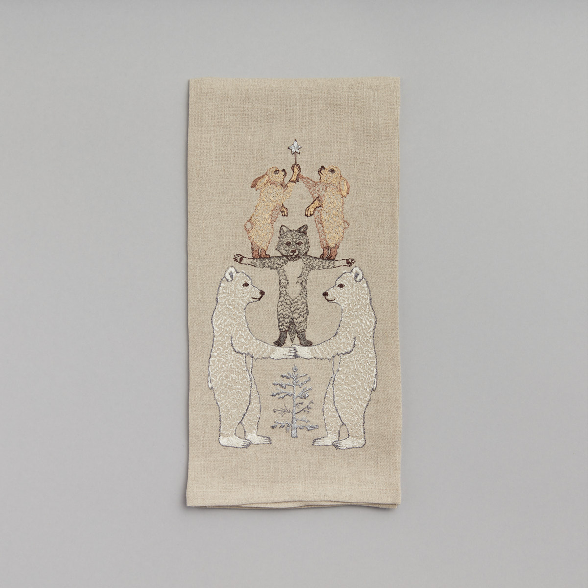 Coral and Tusk's "Arctic Tree" embroidered linen tea towel featuring a stack of wintery animals forming a Christmas tree