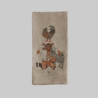Coral and Tusk’s “Barnyard Friends” embroidered linen tea towel featuring a pyramid stack of farm animals