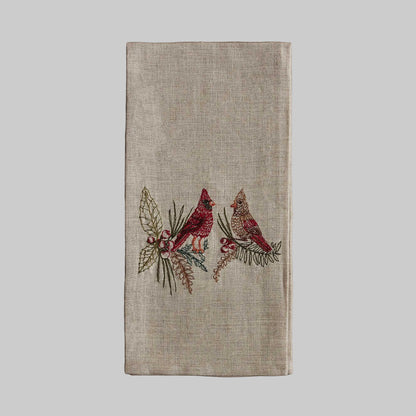 Coral and Tusk’s “Christmas Cardinals” embroidered linen tea towel featuring a male and female cardinal sitting on branches of holly and pine