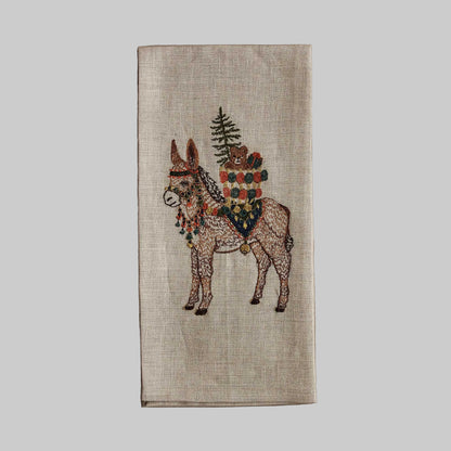 Coral and Tusk’s “Christmas Donkey” embroidered linen tea towel featuring a festive donkey carrying gifts on its back