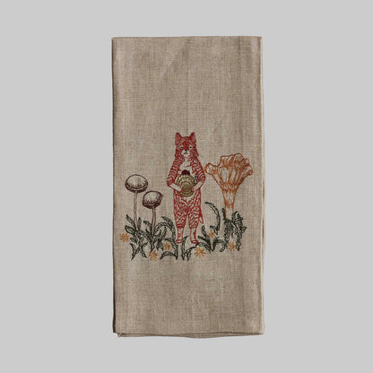 Coral and Tusk’s “Fox with Mushrooms” embroidered linen tea towel featuring a fox standing among several mushrooms