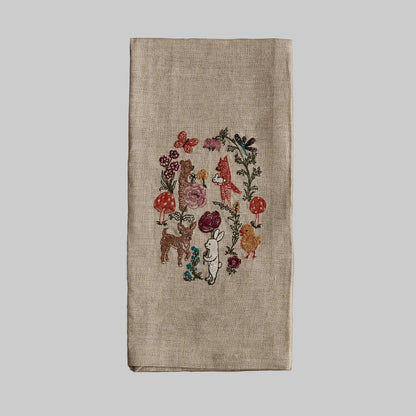Coral and Tusk’s “Secret Garden” embroidered linen tea towel featuring a variety of animal friends gathering in a garden
