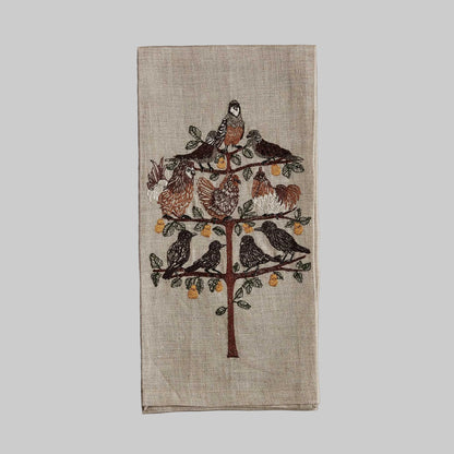 Coral and Tusk’s “Partridge in a Pear Tree” embroidered linen tea towel featuring a variety of birds sitting on the branches of a pear tree