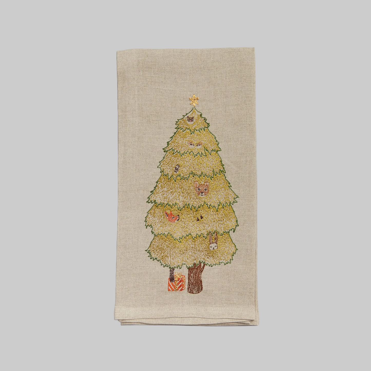 Coral and Tusk's "Peek a Tree" embroidered linen tea towel featuring woodland creatures peeking through an evergreen Christmas tree