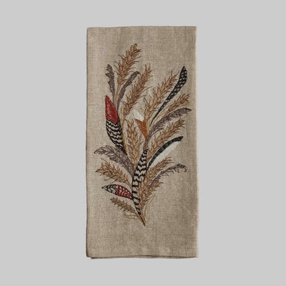 Coral and Tusk’s “Wheat Harvest” embroidered linen tea towel featuring a bouquet of wheat, grass, and found feathers