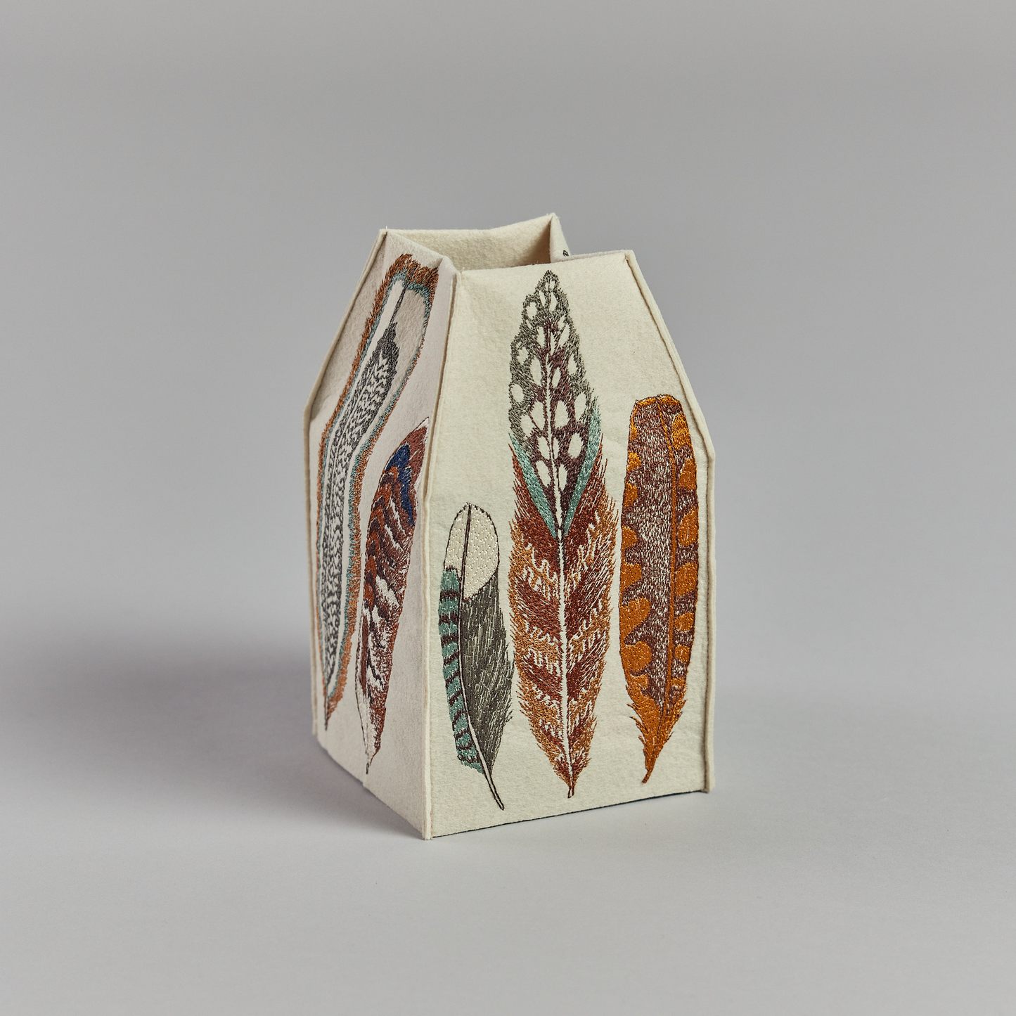 Coral and Tusk's "Feathers" tissue box cover made of felt and embroidered with a varied feather design