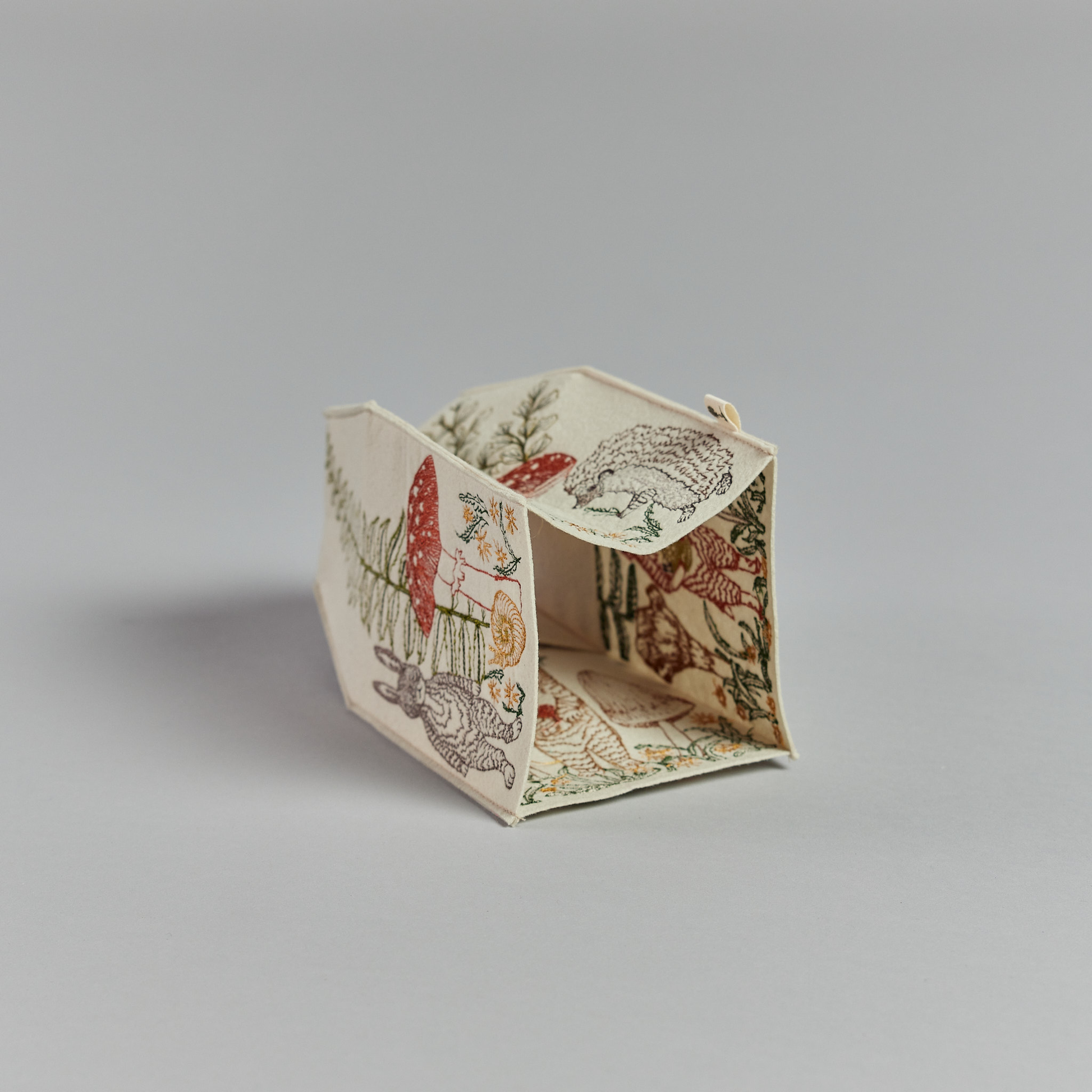 Coral and Tusk's "Mushrooms and Ferns" tissue box cover made of felt and embroidered with animal, mushroom, and fern designs