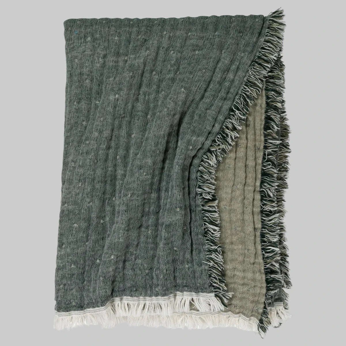Johanna Howard Home's woven Cozi Throw blanket in green, made of cotton, wool, and nylon.