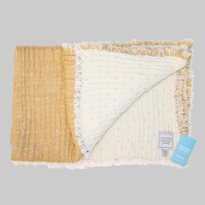 Johanna Howard Home's woven Cozi Throw blanket in yellow, made of cotton, wool, and nylon.