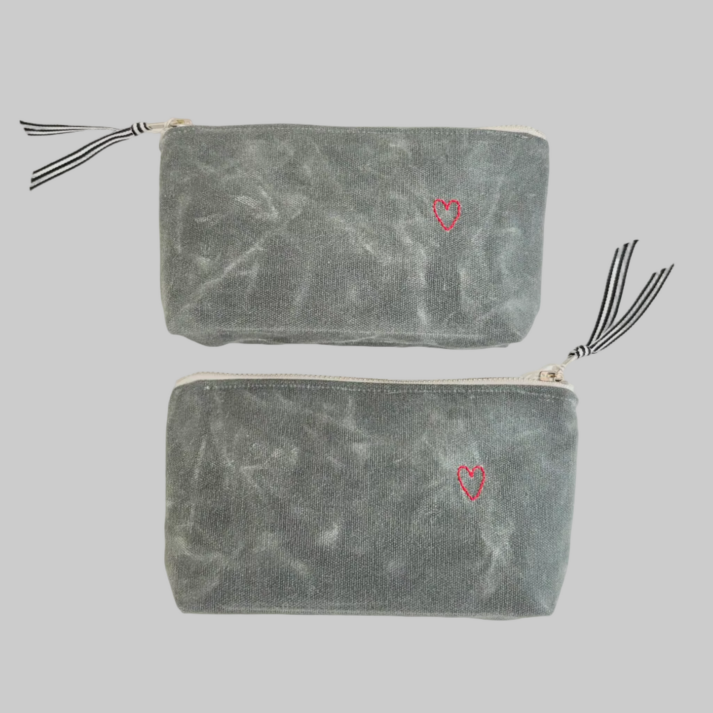 K. Studio’s waxed canvas pouches with embroidered small red heart designs and metal zippers