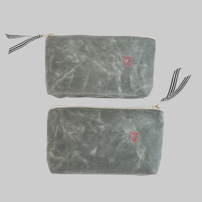 K. Studio’s waxed canvas pouches with embroidered small red heart designs and metal zippers