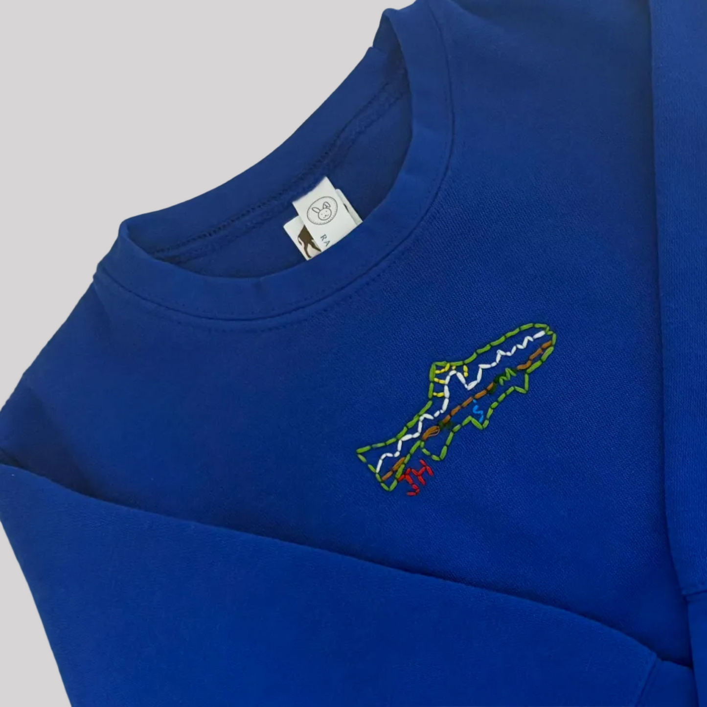 Roam Wild Good’s hand-embroidered kids sweatshirt in blue with trout and Teton mountain design inspired by Jackson Hole, Wyoming