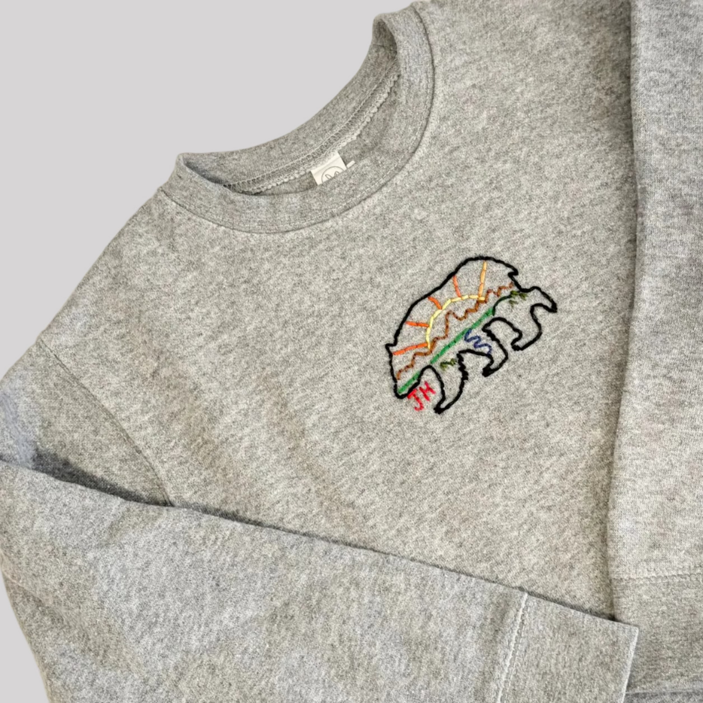 Roam Wild Good’s hand-embroidered kids sweatshirt in gray with bear and Teton mountain design inspired by Jackson Hole, Wyoming