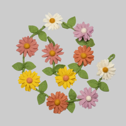Wool-felted garland from The Winding Road featuring pink, orange, and white daisies, use for house decor or kids room