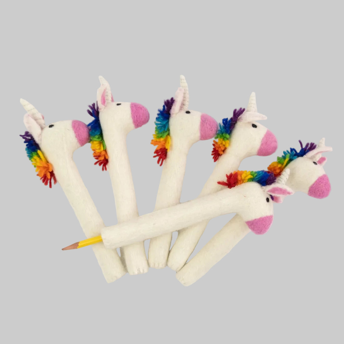 The Winding Road's felted pencil toppers designed to look like a white unicorn with a rainbow mane. Fair trade and made of 100% wool.