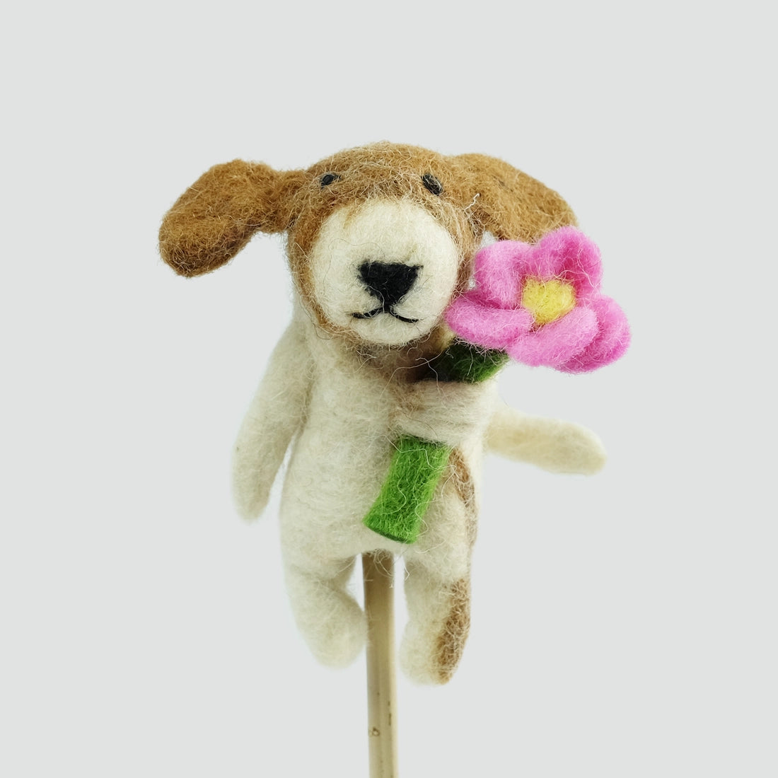 The Winding Road’s wool-felted dog finger puppet holding a flower
