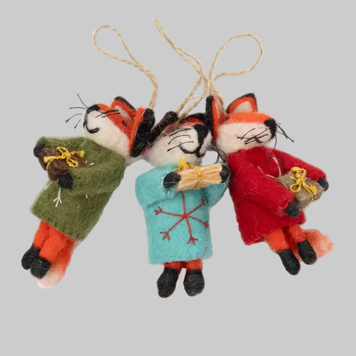 The Winding Road's wool-felted ornaments featuring festive foxes holding gifts. Handmade and fair trade.